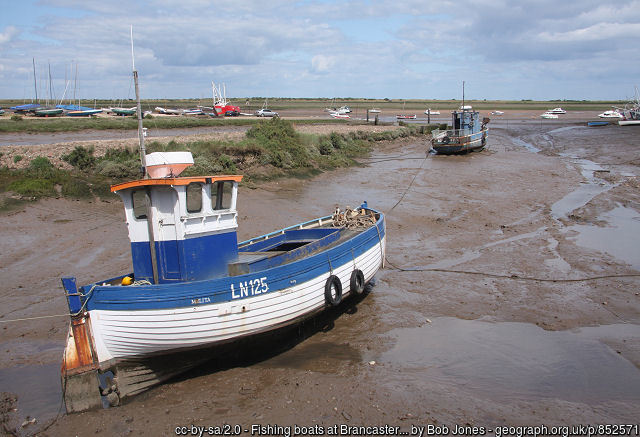 Small fishing boat on a mud flat in Brancaster by Bob Jones